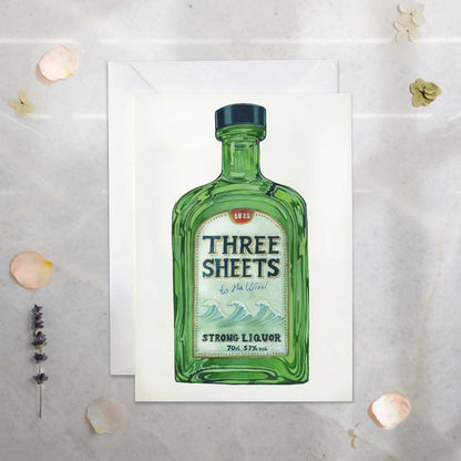 greetinsg Card with a green liquor bottle illustration labeled 'Three Sheets' on a textured surface.