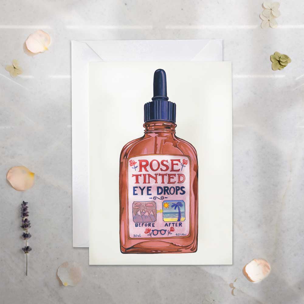Card with illustration of a bottle labeled 'Rose Tinted Eye Drops' on a textured surface.