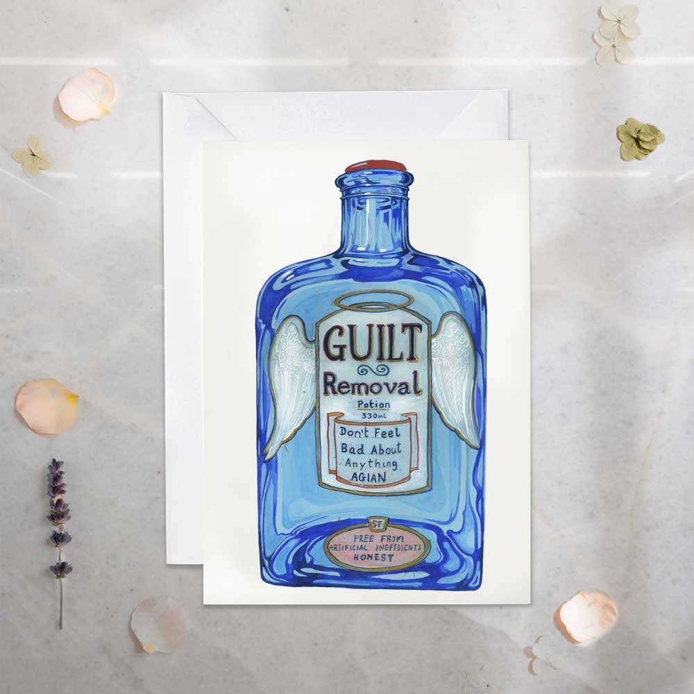 Blue bottle-shaped card with 'Guilt Removal' text on a textured surface.